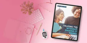 A tablet displaying the 'More Than Type 1' guide titled 'Talking T1D Without Making It Weird,' surrounded by a pink keyboard, succulent plant, notebook, pen, and a blood glucose meter showing 96 mg/dL, all arranged on a pink background